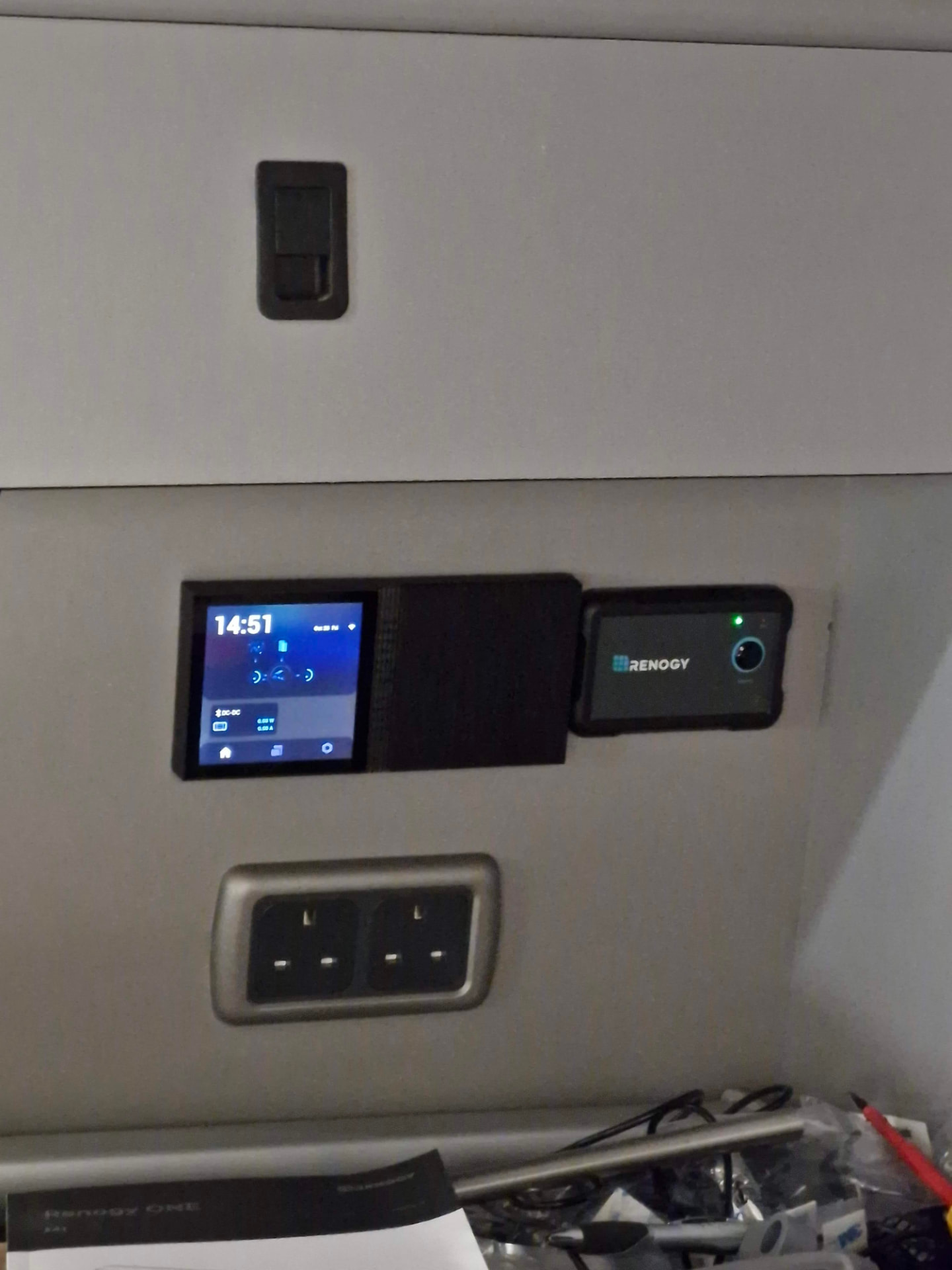 Battery monitoring display, Renogy control panel and 230V sockets fitted into a campervan furniture panel